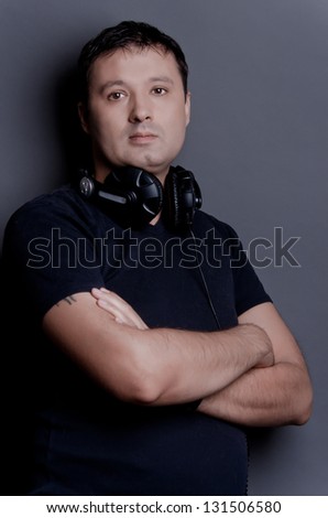 Nice young man with headphones on gray background