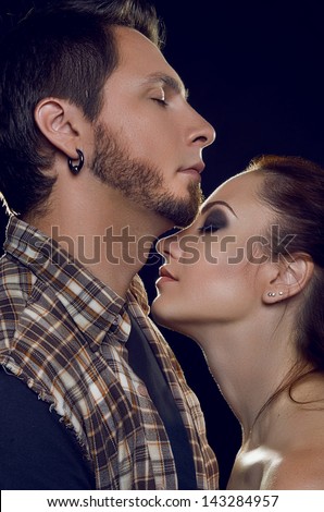 Couple of lovers. Cost profile, facing each other with their eyes closed, changes require pressed against each other on a black background