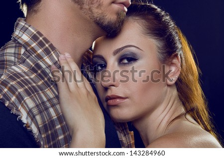 Couple of lovers. Cost profile. The girl gently laid her head on his chest guy. Black background