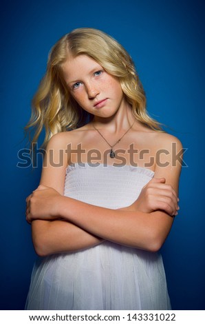 Beautiful blonde girl is offended on a blue background