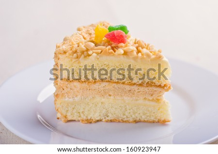 Delicious biscuit cake sprinkled with chopped nuts with pieces of dried pineapple