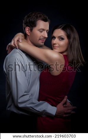 Beautiful couple in love. The woman hugs the man\'s neck. A man looks at a woman romantic look