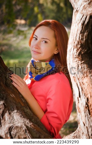 Nice woman in a park in autumn. Dressed in a cape coral