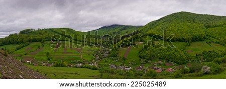 View of the village in a mountain area. Green hills. Cloudy. Ukrainian Carpathians