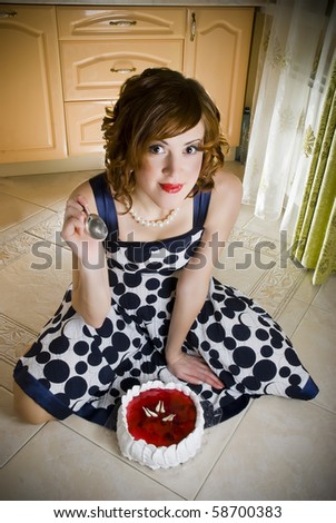 girl eating cake on the kitchen floor with a spoon