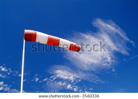 a wind sock and cloudy sky in the background