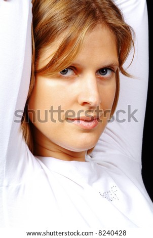 a pretty woman with white sweater holds arm upward