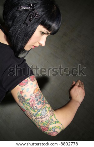 stock photo a woman with black hair and tattooed upper arm