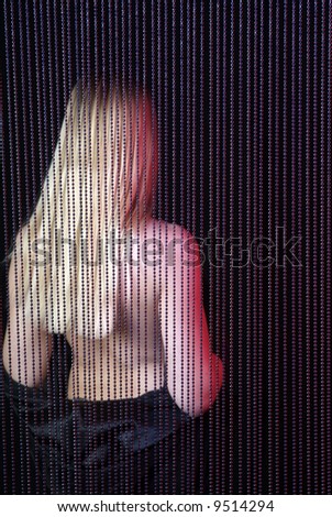 back of a blond woman on black background and pearl