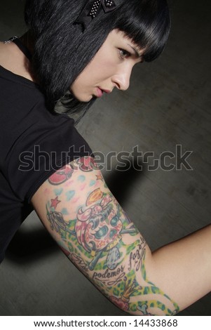 young blackhaired woman with coloured tattoo on upper arm