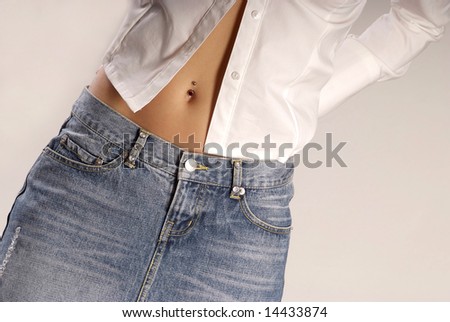 belly of a young woman with piercing looking out of blouse