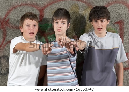 Three young boys showing something with their fingers