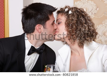 stock photo Bride and groom kissing at the wedding table