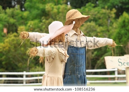 2 scarecrows stand together in the garden