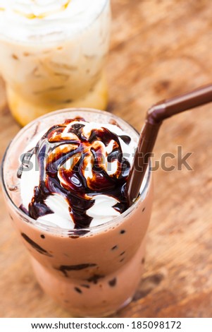 iced chocolate drink topped with whipping cream and chocolate syrup
