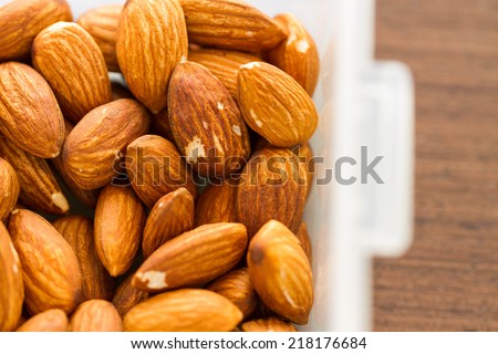 group of almonds in box on wood background