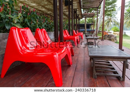 red plastic chairs on wood plank ground at restaurant terrace