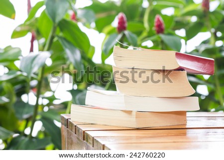 pile of books on wood table in garden