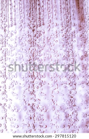 water drops flow from shower in purple tone