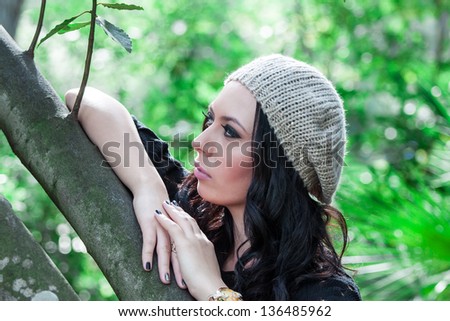 beautiful young woman in hat posing in the park