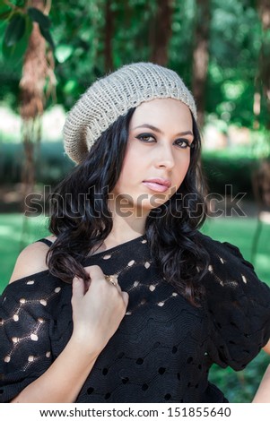 beautiful young woman in hat posing in the park