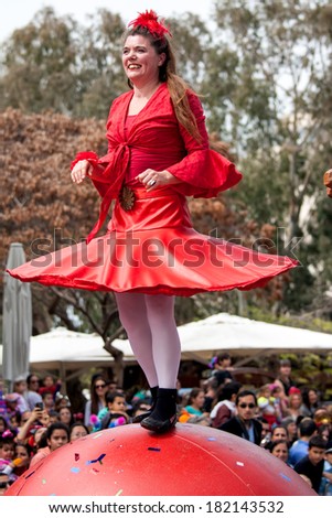 HOLON, ISRAEL - MARCH 16: Unidentified woman walking on the ball through the streets of  Holon during a procession on the feast of Purim carnivall March 16, 2014 in Holon, Israel.