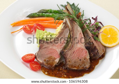 Rosemary roasted lamb chops (ribs) garnished with asparagus, glazed carrots,, grape tomatoes, and micro greeens.