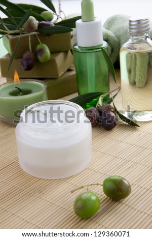 Fancy face cream  with olive soap bars, olive oil, and scented candles for spa treatment