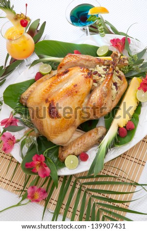 Garnished roasted turkey with tropical fruits, flowers, and refreshing cocktails.