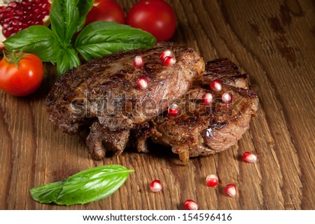 Pan seared beef steaks with fresh tomatoes, basil, and pomegranate.