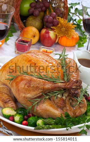 Garnished Roasted Turkey On Fall Festival Decorated Table With Horn Of Plenty And Red Wine