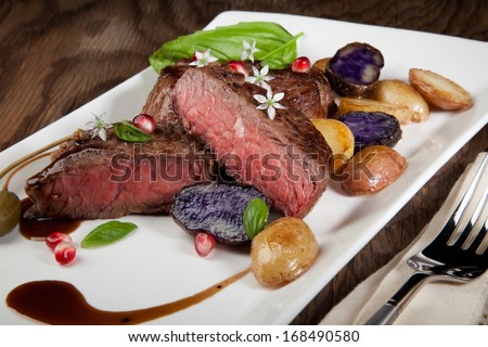 Pan seared steak with fingerling potatoes, capers, pomegranate balsamic vinegar sauce, and fresh basil.