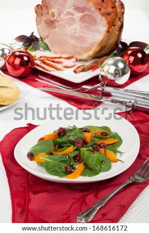 Roasted pumpkin and spinach salad, sage biscuits, and carved roasted spiced ham appetizers with Christmas ornaments.