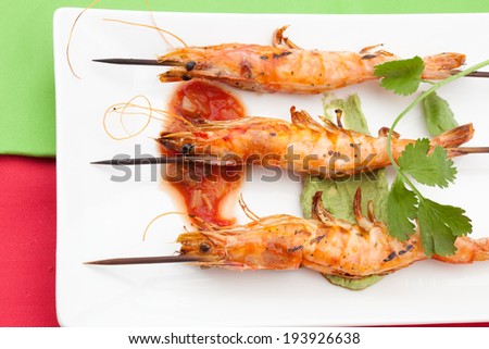 Delicious large spicy grilled whole shrimps -scampi- with salsa and guacamole sauces and fresh cilantro.