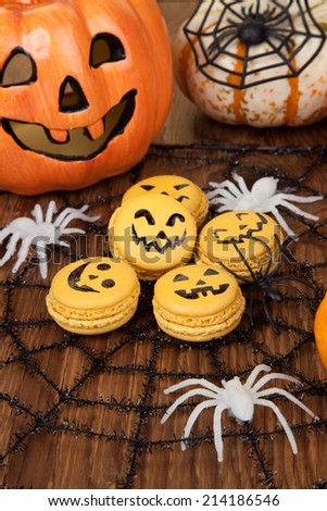 Closeup of Halloween decor with French pumpkin macaroons and assorted pumpkins.