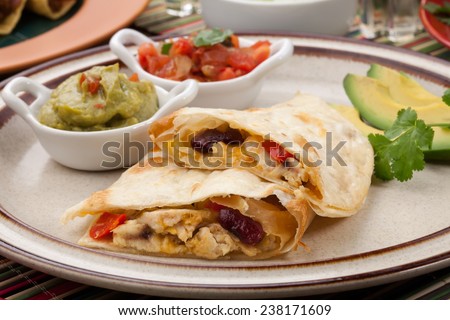 Assorted Mexican dishes, with chicken quesadilla as the main subject.