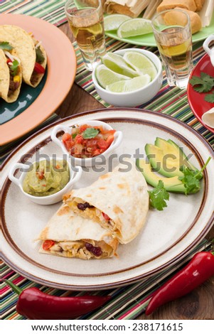Assorted Mexican dishes, with chicken quesadilla as the main subject.