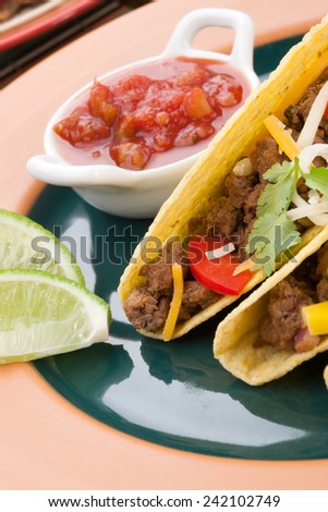 Assorted Mexican dishes, with whole grain corn beef tacos as the main subject.