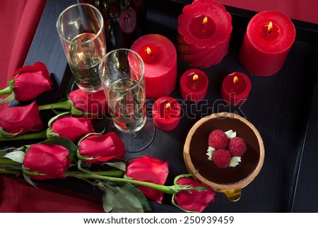 Celebration tray for Valentines Day - Champagne, chocolate raspberry cake, candles, and red roses.
