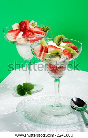 Martini glass full of fresh kiwi, strawberries and cream with organic yogurt