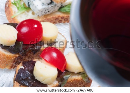 Sandwiches on clear plate and glass of red wine out of focus