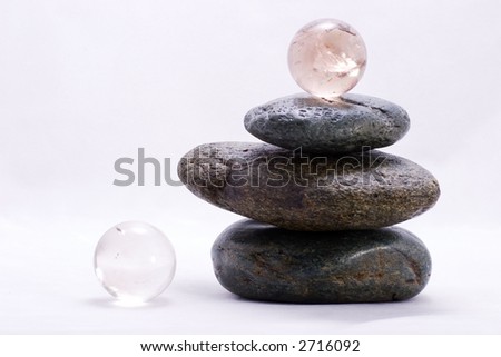 Crystal ball on the top of zen stones pyramid in balance