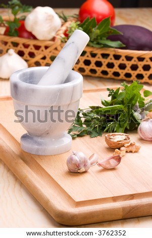 Cooking with culinary herbs, vegetables and marble mortar and pestle