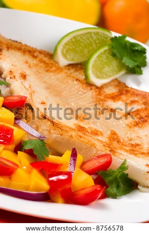Closeup of fried skate (ray) with mango, cherry tomato and red onion salsa.