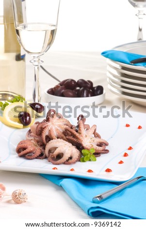 Delicious octopus cooked in red wine sauce, lemon slices and olives