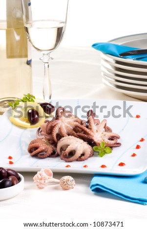 Delicious octopus cooked in red wine sauce, lemon slices and olives