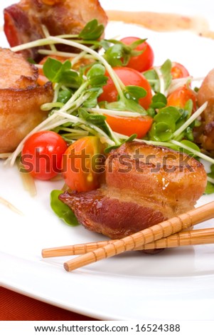 Closeup of Ginger Soy Scallops wrapped by bacon garnished with fresh cherry tomatoes and daikon sprouts.