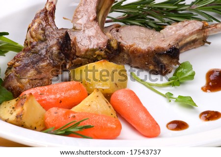 Lamb chops (ribs) with Rosemary garlic dressing, garnished with baby carrots, potatoes and rosemary sprigs. Dinner settings.