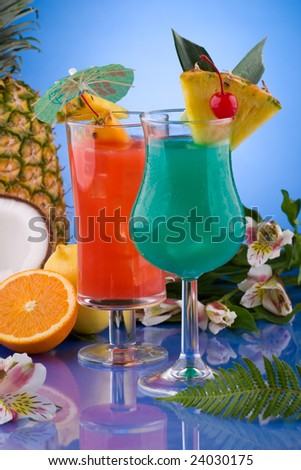 Blue Hawaiian and Hurricane cocktails surrounded by tropical fruits. Most popular cocktails series.