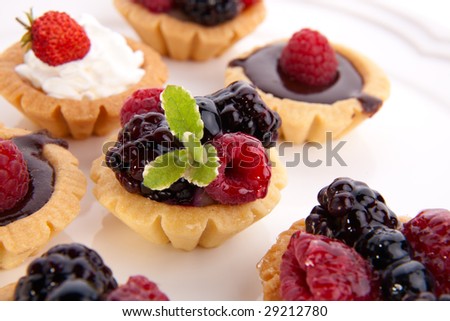 Full tray of delicious fresh berry cakes garnished with pineapple mint